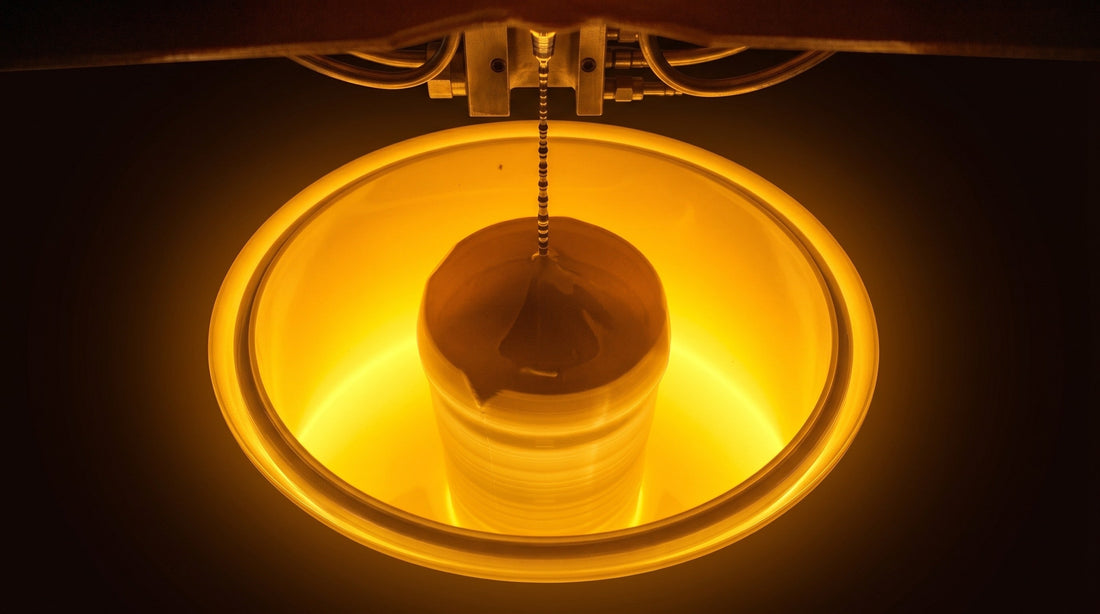 Glowing silicon ingot being pulled from a Czochralski crystal growth furnace during the silicon wafer manufacturing process