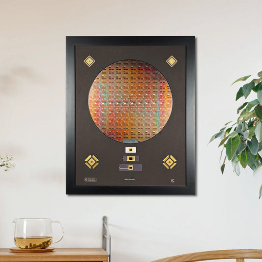 Framed artwork on a wall above a wooden cabinet with a plant and chair in the background.