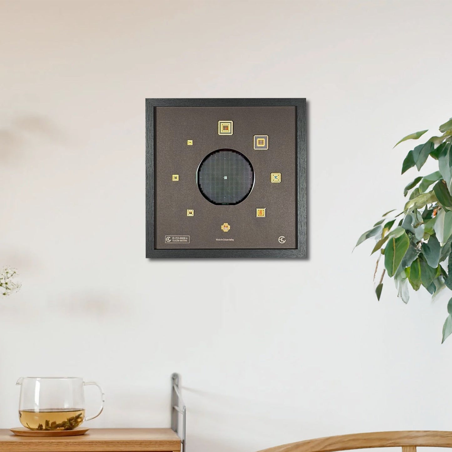 Decorative wall art piece on a white wall with a wooden cabinet and plant in the foreground.
