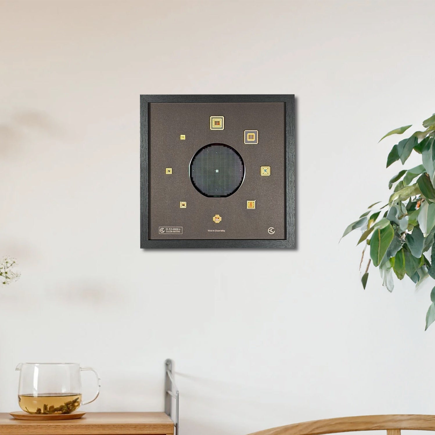 Decorative wall art piece on a white wall with a wooden cabinet and plant in the foreground.