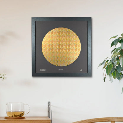 Framed artwork on a wall above a wooden cabinet with a plant and glass in the foreground.