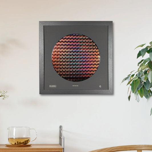 Framed artwork with a colorful circular design on a wall above a wooden cabinet.