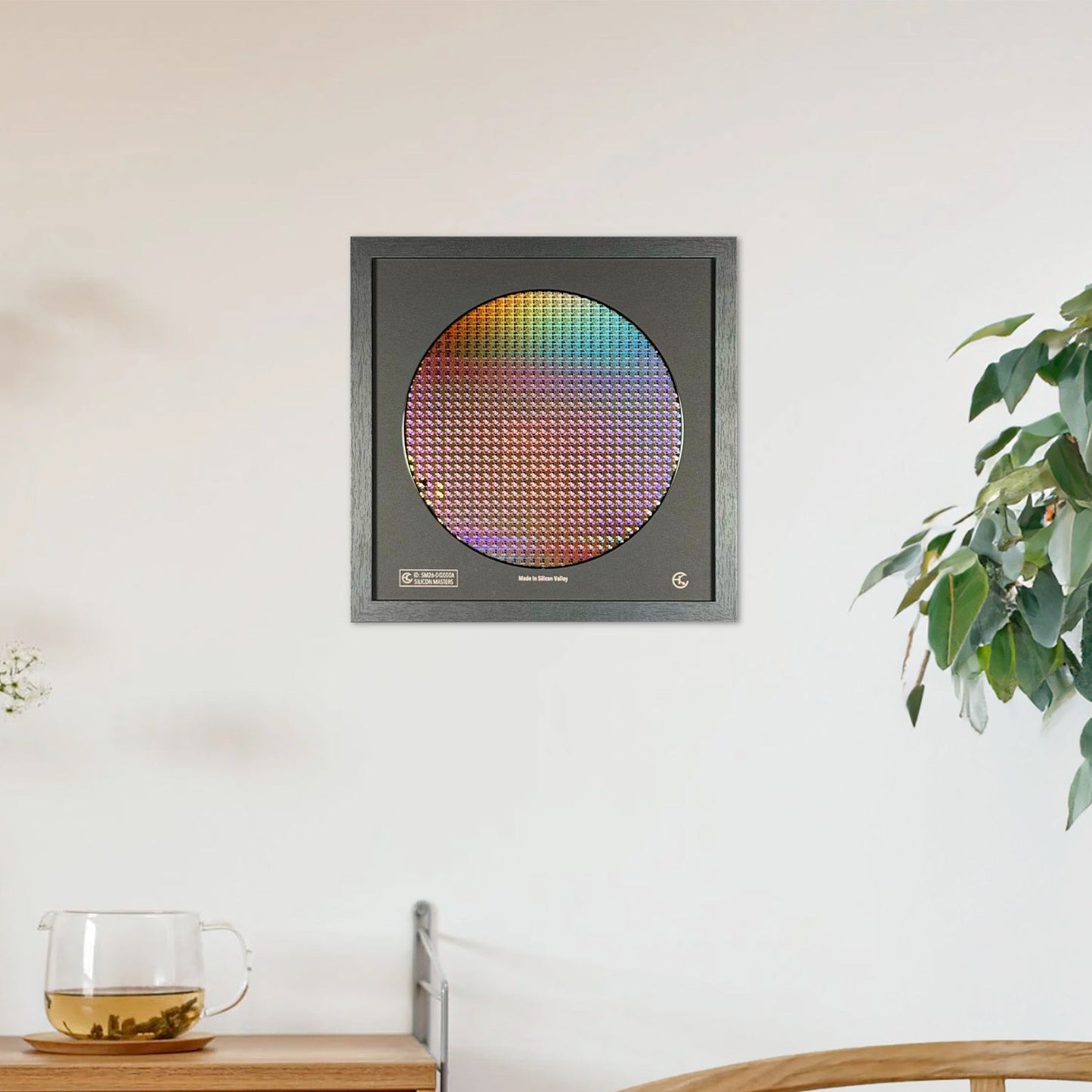 Decorative wall art with a colorful circular design in a gray frame on a white wall.