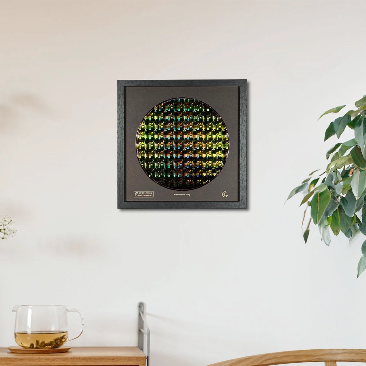 Decorative wall art piece on a white wall with a wooden cabinet and plant in the foreground.