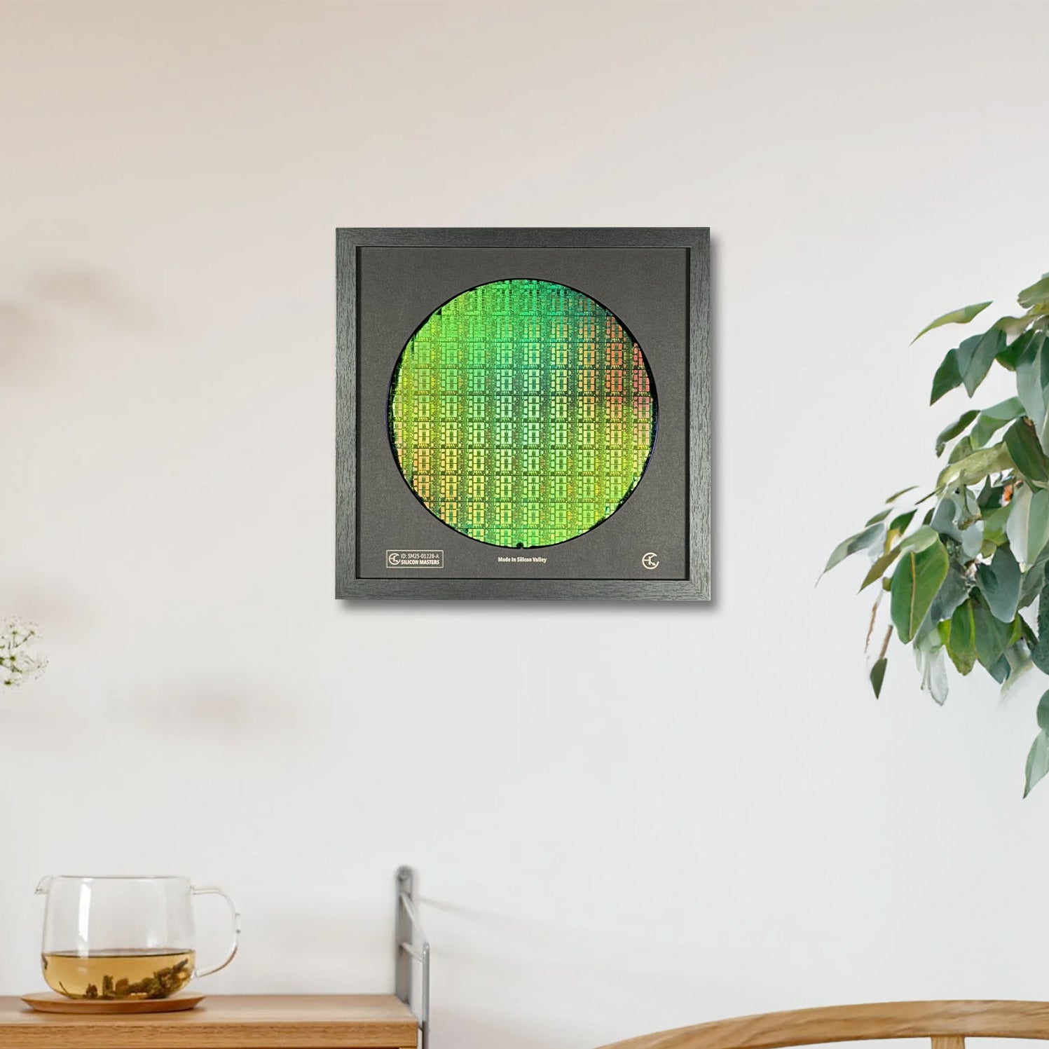 Modern wall clock with green display on a white wall, next to a wooden cabinet and plant.