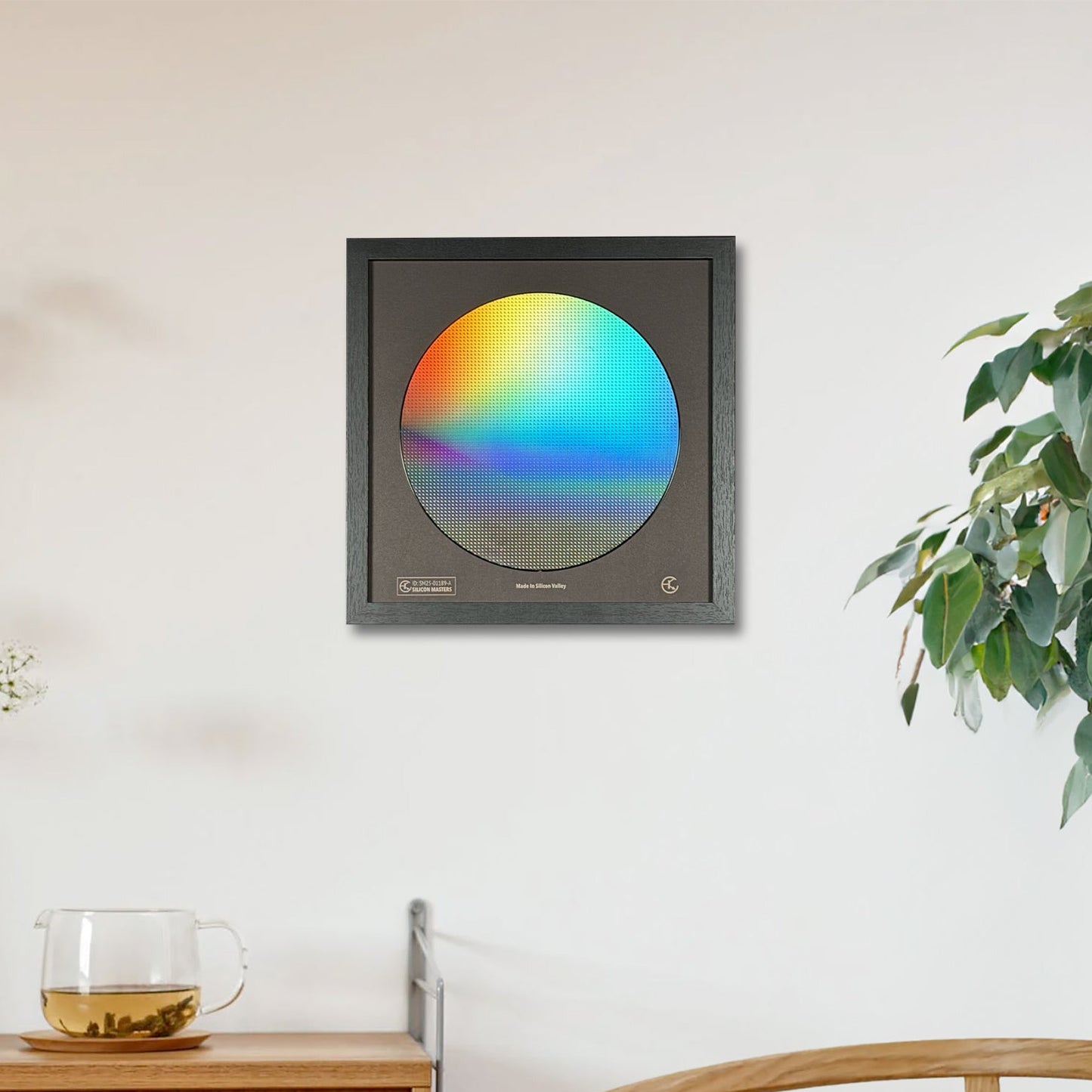 Framed artwork with a colorful circle on a wall in a room with a wooden cabinet and plant.